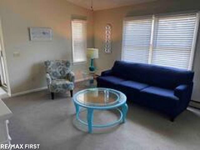 living room featuring vaulted ceiling and baseboards