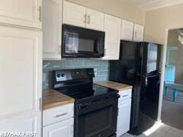 kitchen featuring black appliances, tasteful backsplash, white cabinets, and light countertops