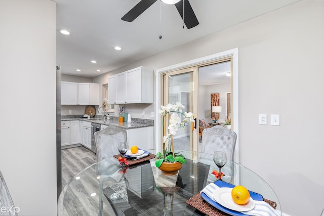 kitchen featuring light stone counters, recessed lighting, a sink, white cabinetry, and dishwasher