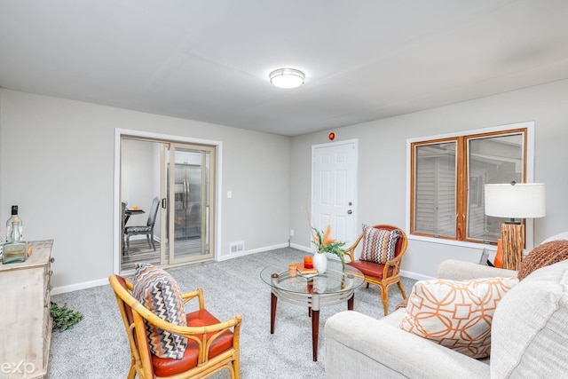 carpeted living area featuring baseboards and visible vents