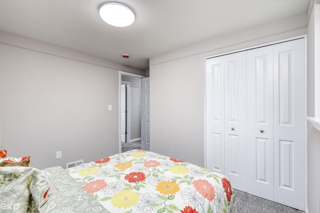 carpeted bedroom featuring a closet and visible vents