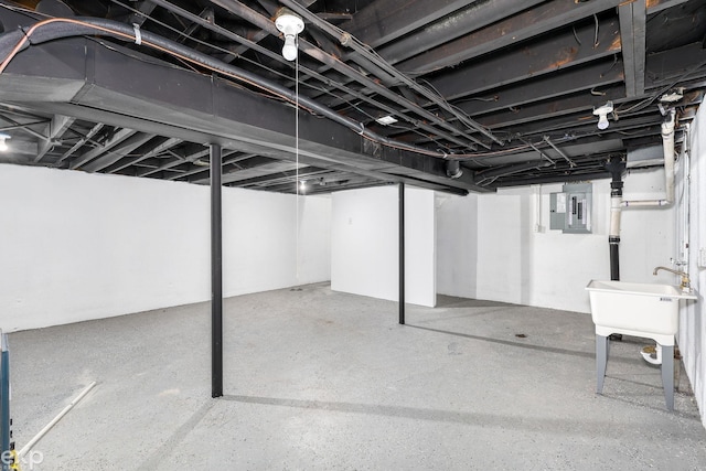 unfinished basement featuring electric panel and a sink