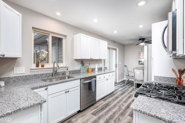 kitchen featuring white cabinetry, stainless steel appliances, a sink, and recessed lighting