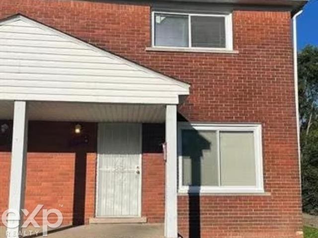 doorway to property with brick siding