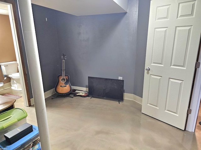 empty room with baseboards and concrete flooring