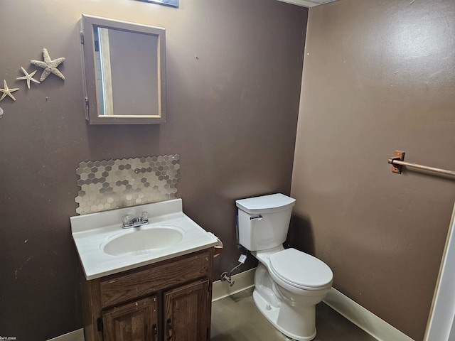 bathroom with toilet, baseboards, and vanity