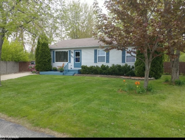 ranch-style house featuring a front lawn and fence