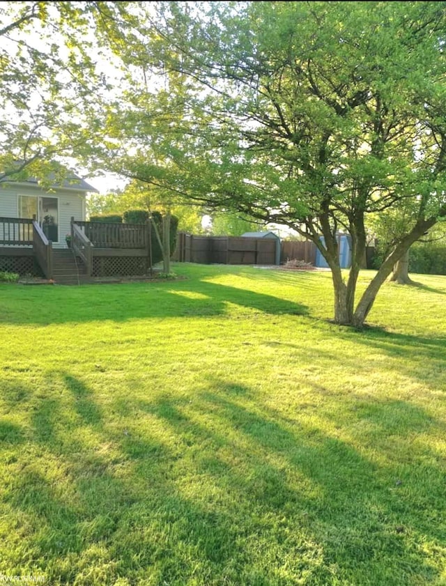 view of yard with fence and a deck