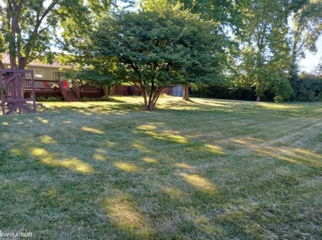 view of yard featuring a shed, a deck, and an outdoor structure