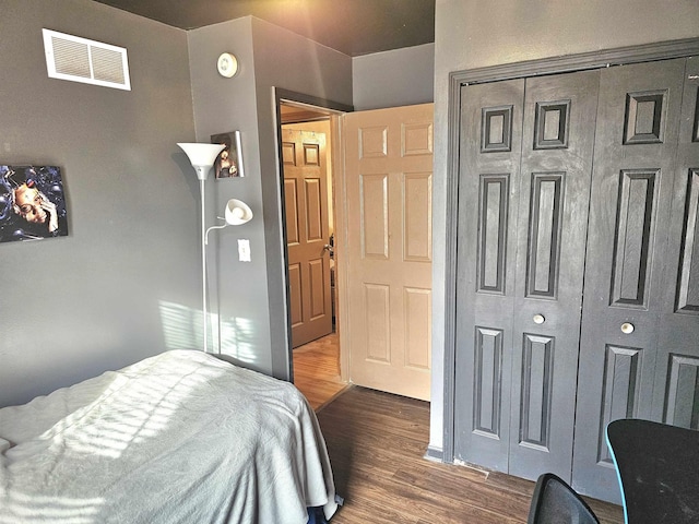 bedroom featuring a closet, visible vents, and wood finished floors