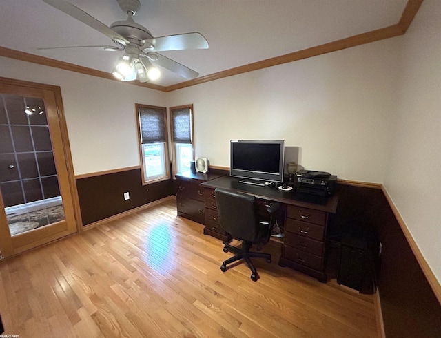 office area featuring baseboards, a ceiling fan, wainscoting, light wood-style flooring, and ornamental molding