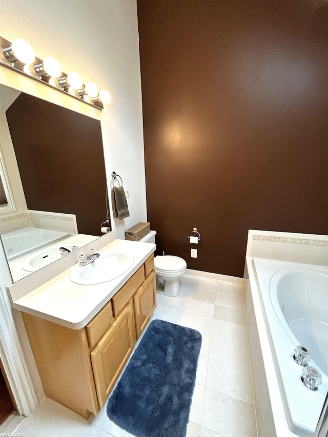 bathroom featuring a jetted tub, vanity, toilet, and tile patterned floors