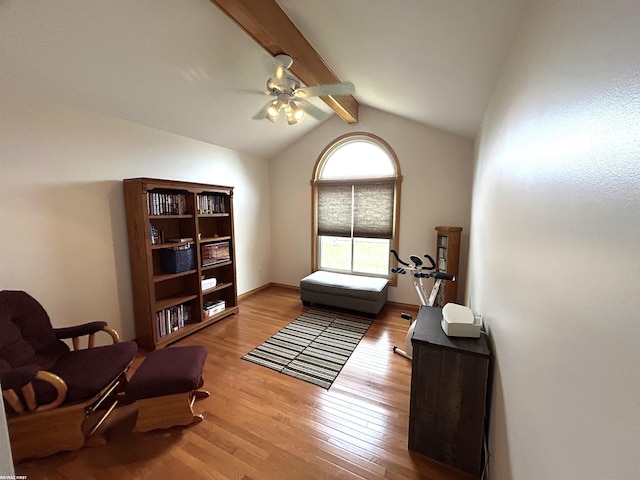 living area featuring lofted ceiling with beams, ceiling fan, hardwood / wood-style floors, and baseboards