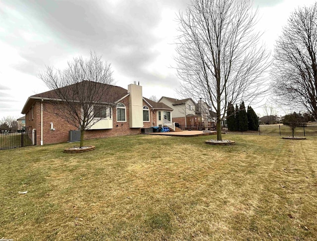 view of yard featuring fence, a deck, and central AC unit