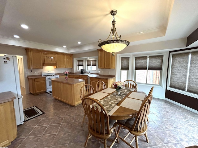 dining space featuring recessed lighting, a raised ceiling, crown molding, and dark tile patterned floors