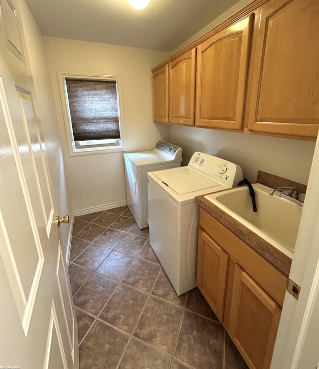 laundry area with dark tile patterned flooring, independent washer and dryer, a sink, and cabinet space