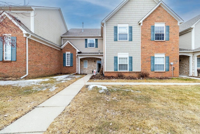 view of front facade featuring a front yard and brick siding