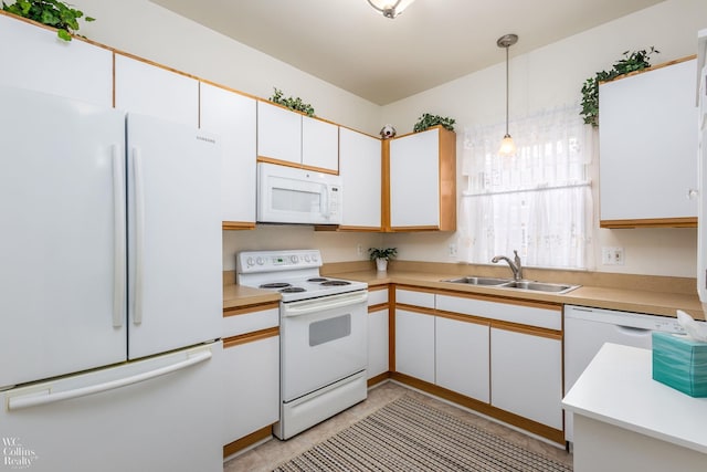 kitchen with white cabinets, white appliances, light countertops, and a sink