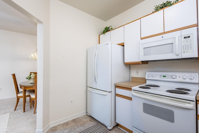 kitchen with white appliances, baseboards, white cabinets, light countertops, and a chandelier