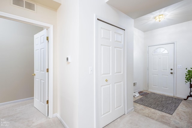 entryway featuring light carpet, baseboards, and visible vents