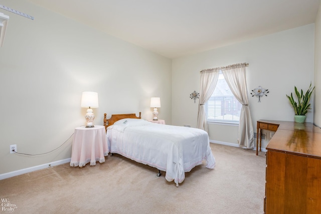 bedroom featuring light carpet and baseboards