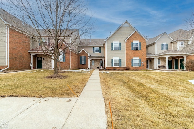 view of front of home with a front lawn and brick siding