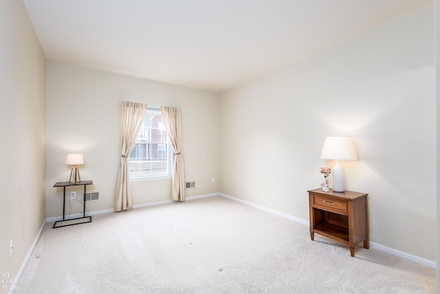 carpeted empty room with visible vents and baseboards