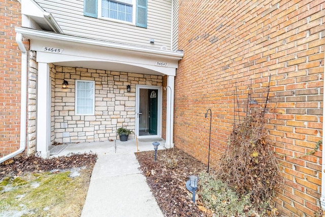 doorway to property with brick siding