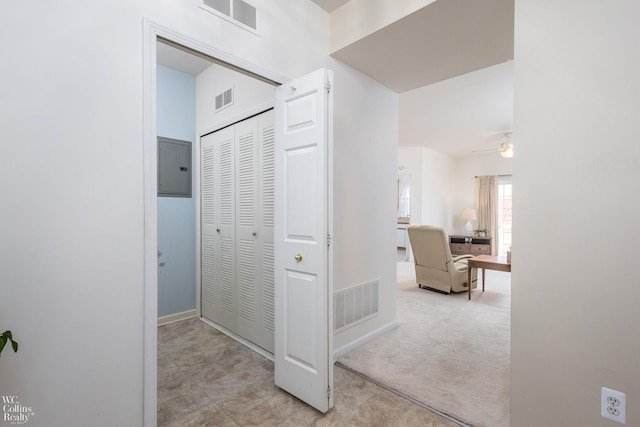 hall featuring carpet, electric panel, and visible vents