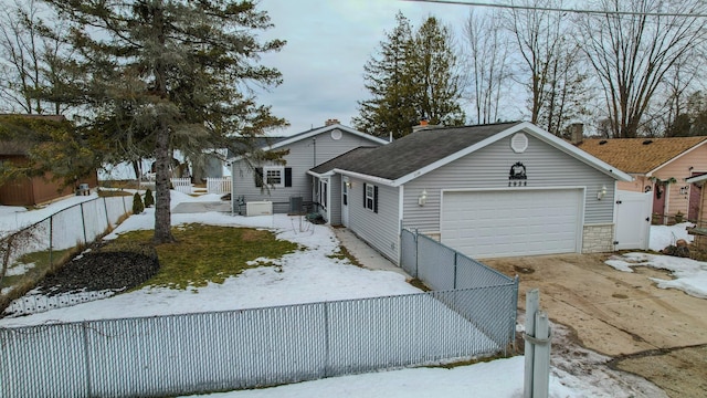 view of front facade with an attached garage, fence private yard, and driveway