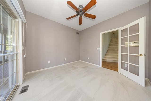 unfurnished room featuring visible vents, stairway, baseboards, and carpet