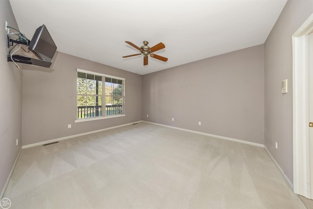 unfurnished room with baseboards, light carpet, visible vents, and a ceiling fan