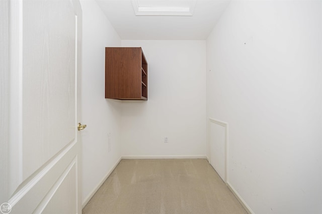 spare room with baseboards, light carpet, and attic access