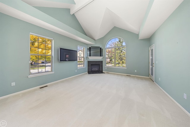 unfurnished living room featuring carpet, baseboards, visible vents, vaulted ceiling with beams, and a tile fireplace