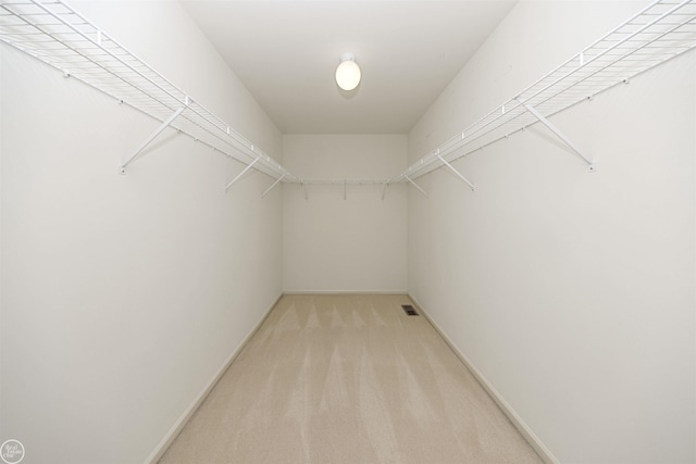 walk in closet featuring visible vents and light colored carpet