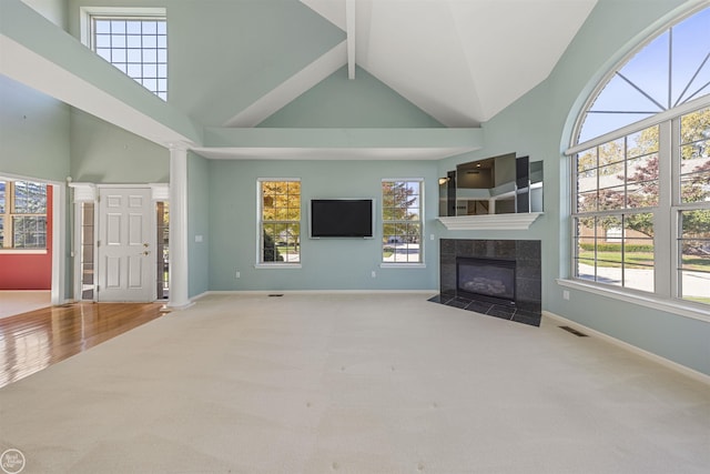 unfurnished living room with visible vents, high vaulted ceiling, a fireplace, and carpet