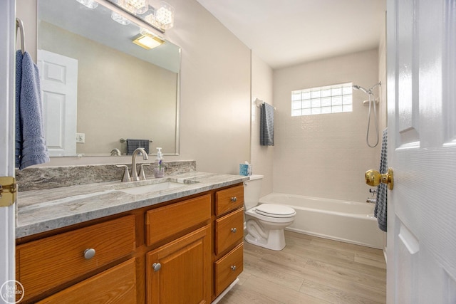 bathroom with shower / bathtub combination, vanity, wood finished floors, and toilet