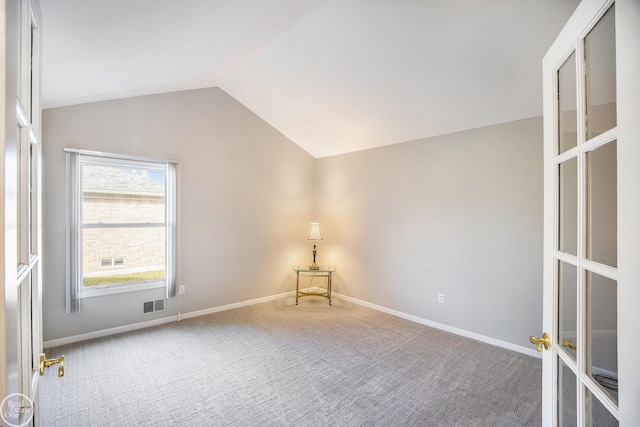 unfurnished room featuring carpet floors, french doors, lofted ceiling, visible vents, and baseboards