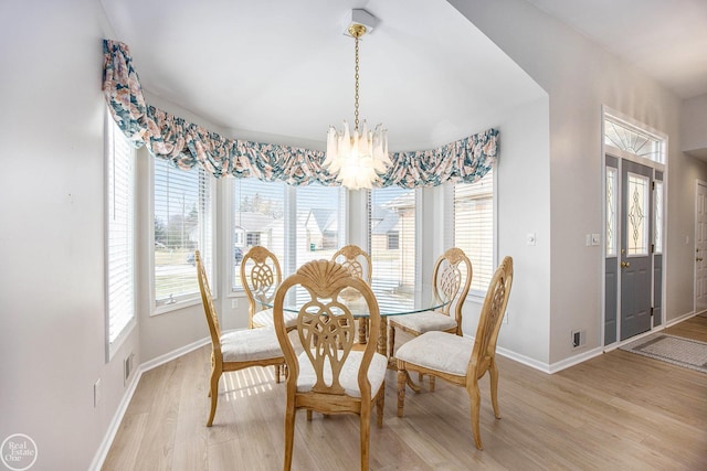 dining room featuring light wood-style flooring, a chandelier, and baseboards