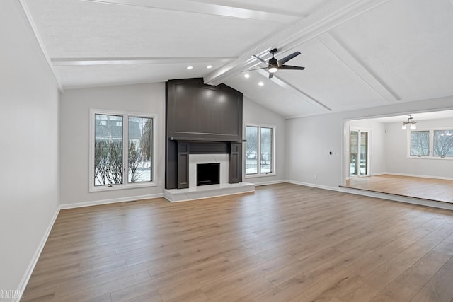 unfurnished living room with light wood-type flooring, a fireplace, and a wealth of natural light