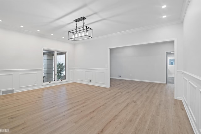 interior space featuring recessed lighting, visible vents, a decorative wall, ornamental molding, and light wood-style floors