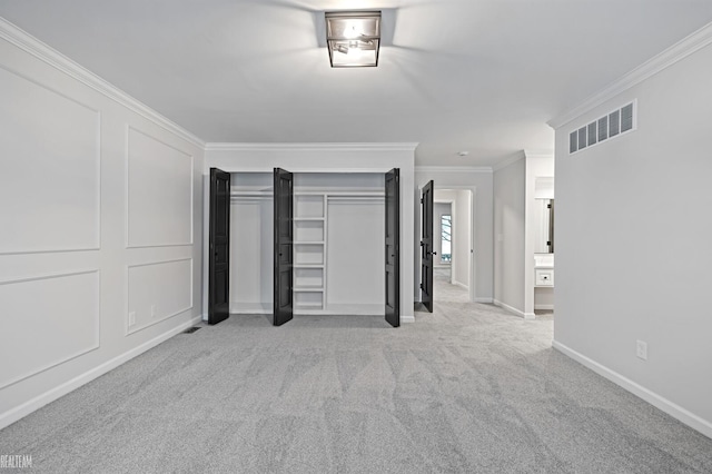 unfurnished bedroom featuring light colored carpet, visible vents, baseboards, a closet, and crown molding