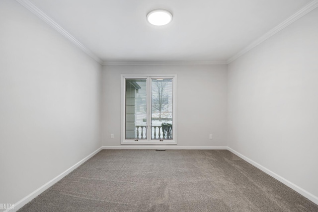 spare room featuring crown molding, carpet, and baseboards