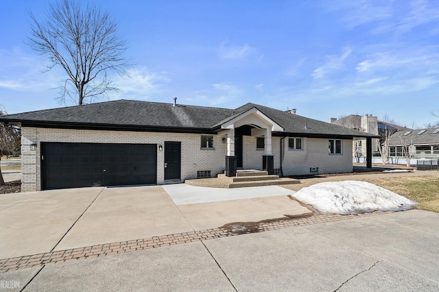 view of front of house with a garage, driveway, brick siding, and a shingled roof