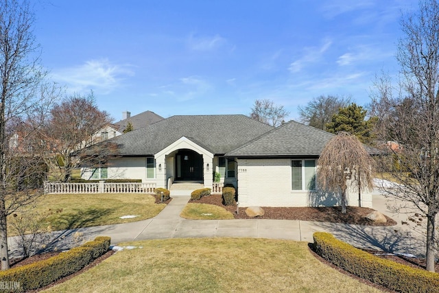 ranch-style home with brick siding, roof with shingles, fence, driveway, and a front lawn