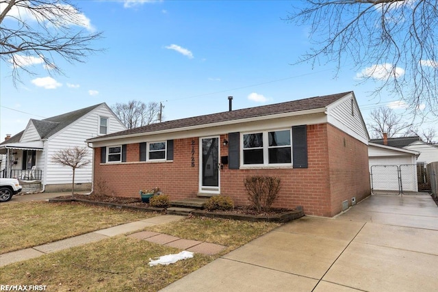 view of front of house featuring a garage, a front lawn, and brick siding