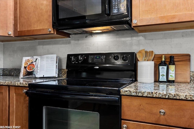 kitchen with black appliances, brown cabinetry, light stone countertops, and decorative backsplash