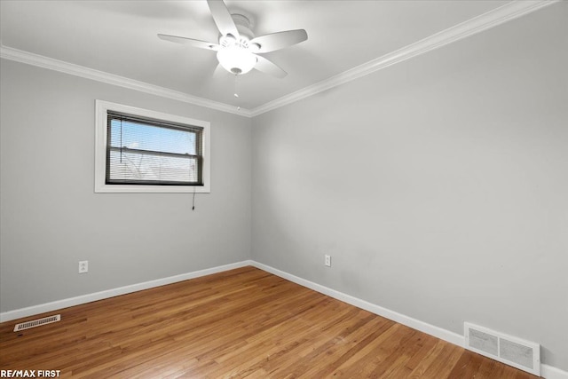 empty room featuring baseboards, light wood-style floors, visible vents, and crown molding