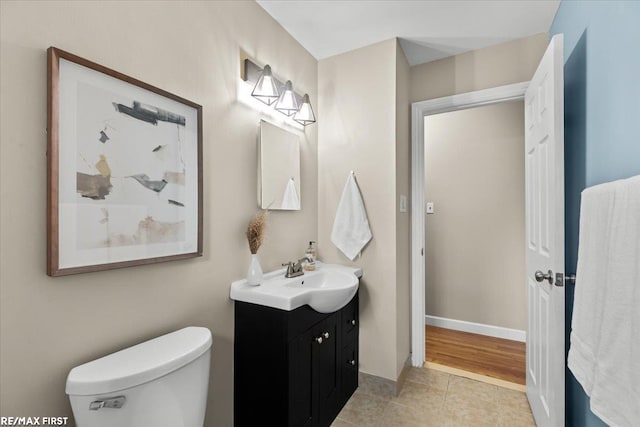 bathroom featuring toilet, tile patterned flooring, baseboards, and vanity