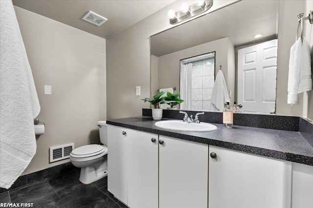 bathroom featuring toilet, vanity, and visible vents